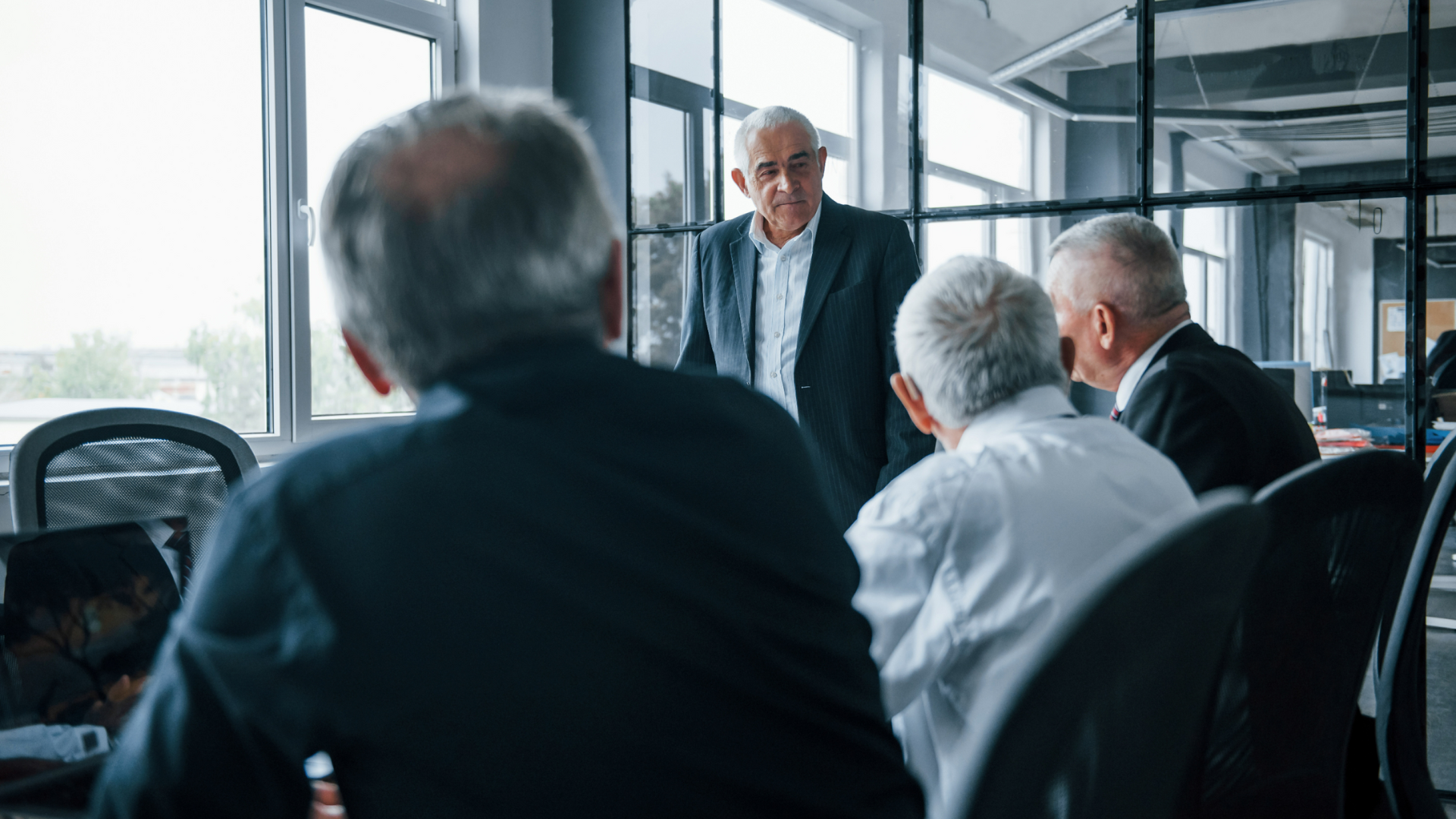 Senior business leader discussing strategic sale with potential buyers in a meeting