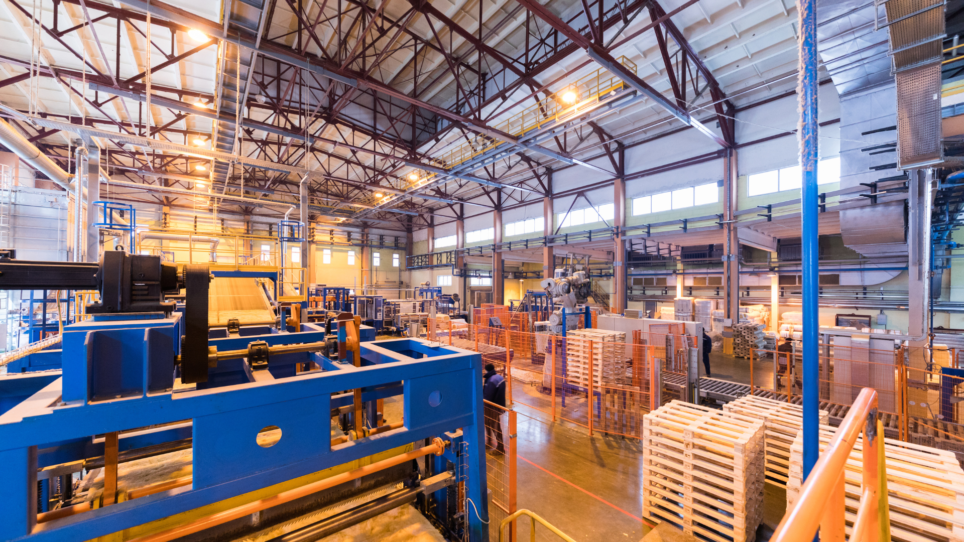 Owner standing in a modern CNC manufacturing facility reviewing business documents before selling